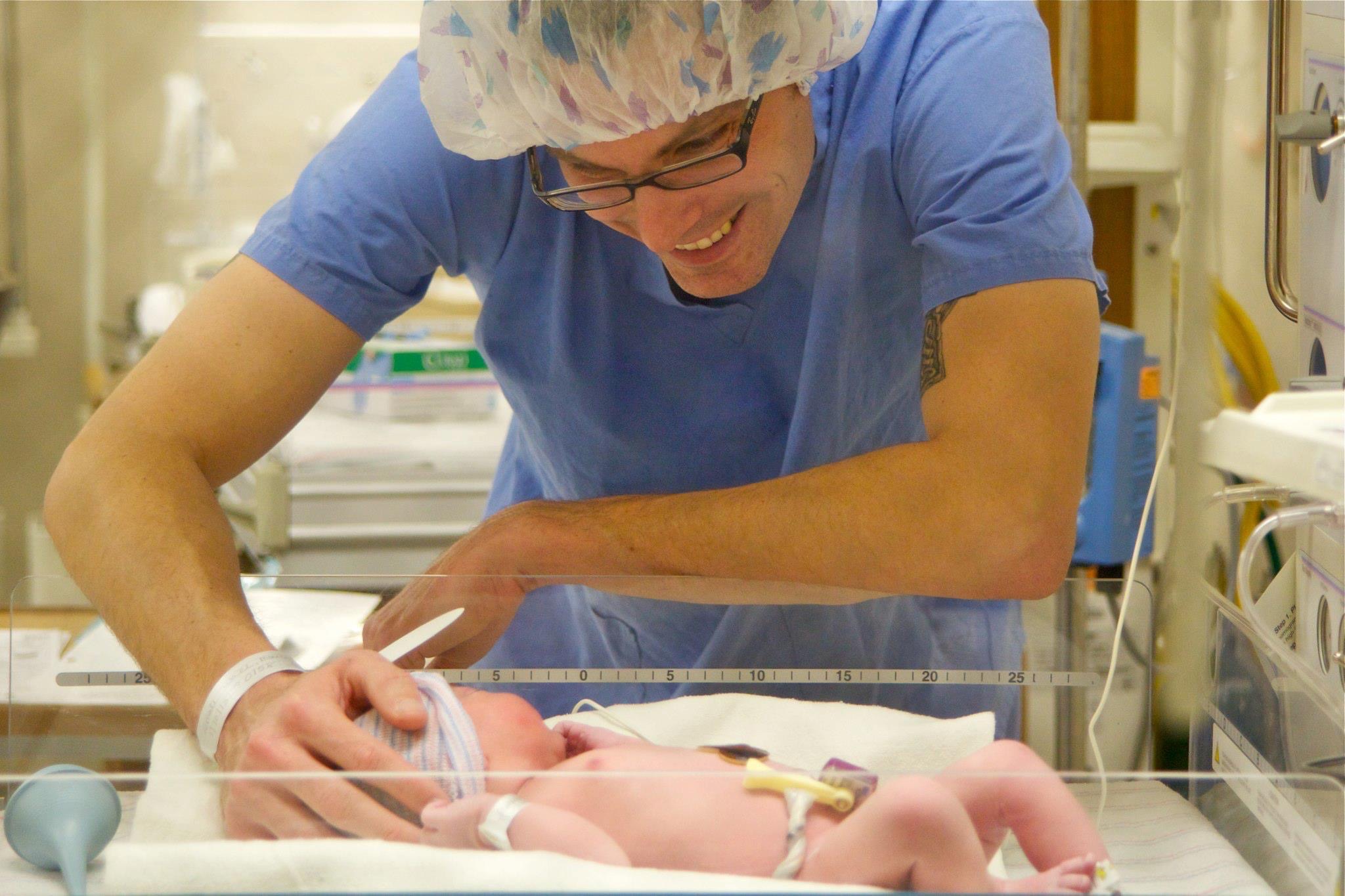 Newborn baby in hospital with hand over them