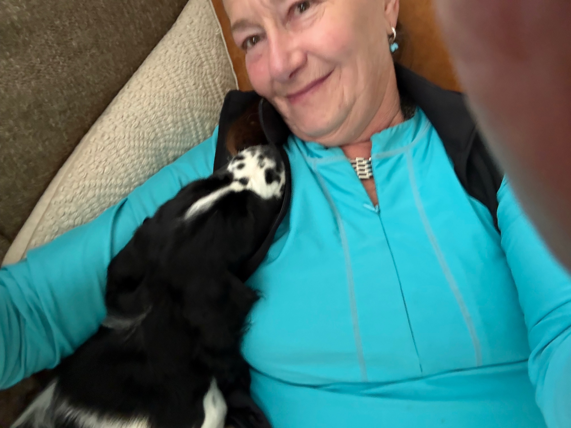 Carol cuddling with an English Springer Spaniel on the sofa