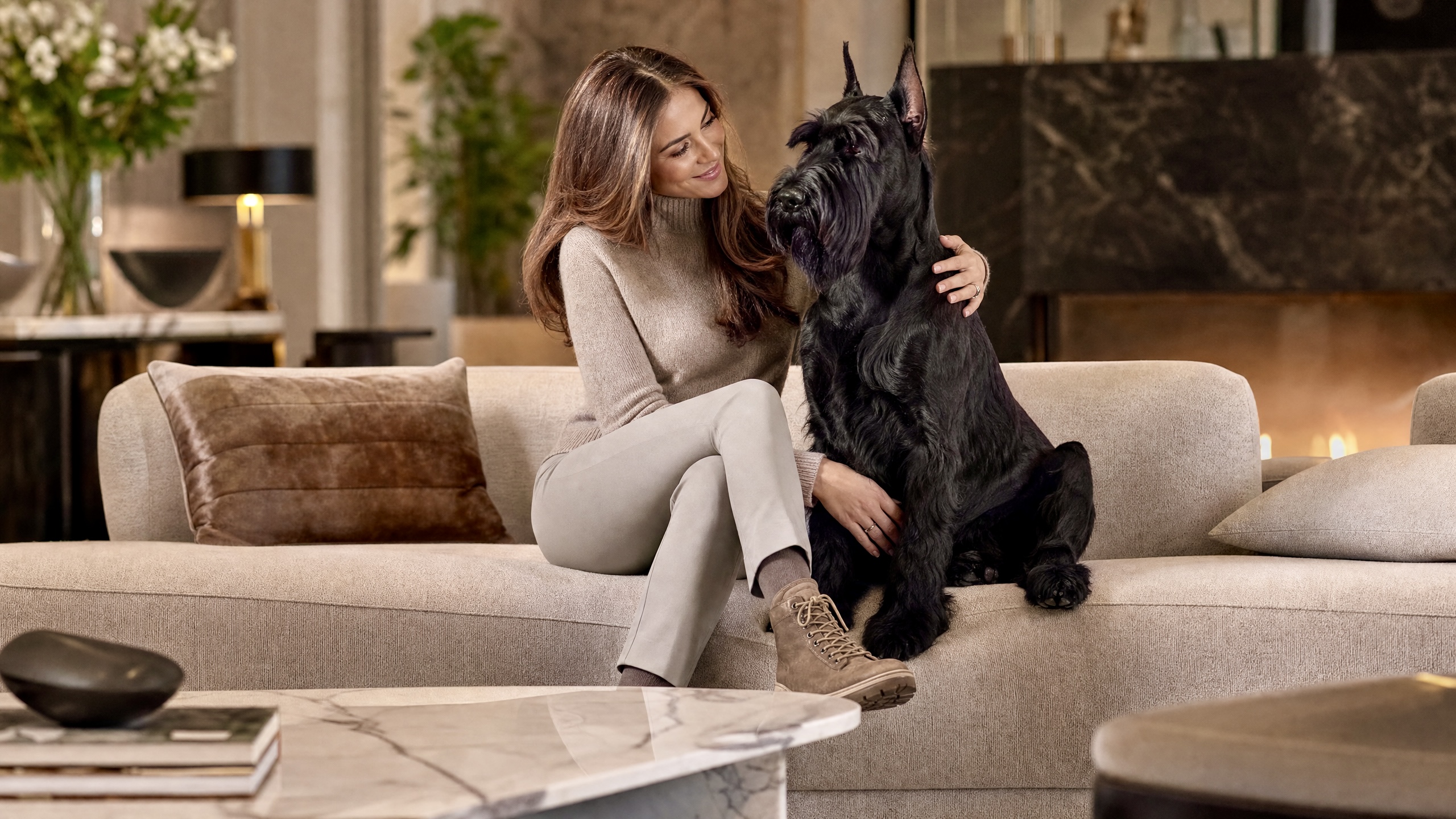 Carol with her regal Giant Schnauzer on a cozy sofa